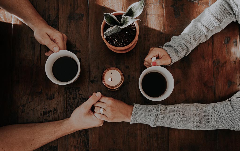 Hands of two person on a table who understand the characteristics and purpose of counselling